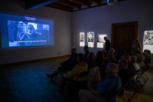 Wystawa: Powroty - Publiczność wernisażu podczas projekcji filmu.