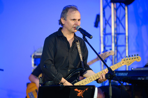 Koncert "Pawel Mazur - Przyjaciele i uczniowie" - Scena tarnowskiego Amfiteatru podczas koncertu. Paweł Mazur śpiewa i gra na gitarze.