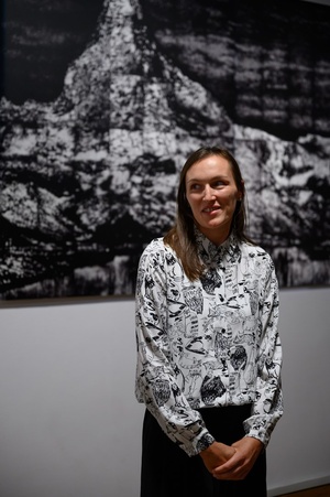 Wystawa: Tańcząc ze światłem - Autorka wystawy Michalina Hedrys podczas przemowy na otwarciu na tle jednej ze swoich prac.