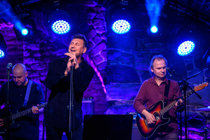 Koncert: Zaduszki - Scena w Piwnicach TCK. Rafał Huszno podczas występu, w tle Grzegorz Nosek i Paweł Mazur.