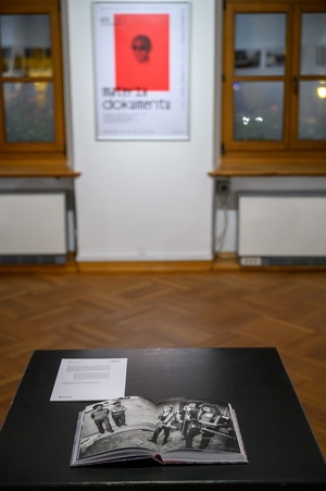 Wystawa: Materia dokumentu - Książka "Kurz" autorstwa Mariusza Foreckiego, część ekspozycji, na drugim planie plakat wystawy.