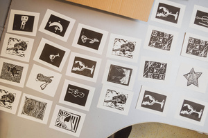 Artystyczne Ferie - tydzień II - Na fotografii uwieczniono grupę uczestników – dzieci, młodzież oraz dorosłych – zaangażowanych w warsztaty tworzenia Artbooków. Widoczne są różnorodne narzędzia, w tym prasa drukarska, z których korzystają pod czujnym okiem prowadzących.