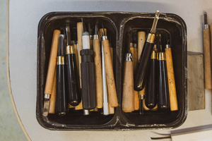 Artystyczne Ferie - tydzień II - Na fotografii uwieczniono grupę uczestników – dzieci, młodzież oraz dorosłych – zaangażowanych w warsztaty tworzenia Artbooków. Widoczne są różnorodne narzędzia, w tym prasa drukarska, z których korzystają pod czujnym okiem prowadzących.