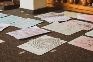 Artystyczne Ferie - tydzień II - Na fotografii uwieczniono grupę uczestników – dzieci, młodzież oraz dorosłych – zaangażowanych w warsztaty tworzenia Artbooków. Widoczne są różnorodne narzędzia, w tym prasa drukarska, z których korzystają pod czujnym okiem prowadzących.