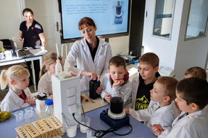 Naukowe Ferie w Pasażu Odkryć - Na zdjęciu przedstawieni są uczestnicy – dzieci i młodzież – zaangażowani w aktywności edukacyjne w różnych pracowniach naukowych, takich jak chemiczna, stolarska, planetarium oraz informatyczna. Widoczne są sceny, gdzie uczą się i przeprowadzają eksperymenty pod nadzorem instruktorów.