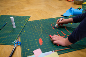 Naukowe Ferie w Pasażu Odkryć - Na zdjęciu przedstawieni są uczestnicy – dzieci i młodzież – zaangażowani w aktywności edukacyjne w różnych pracowniach naukowych, takich jak chemiczna, stolarska, planetarium oraz informatyczna. Widoczne są sceny, gdzie uczą się i przeprowadzają eksperymenty pod nadzorem instruktorów.