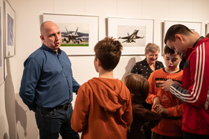 Wernisaże dzień po dniu: Paweł Wadas / Krzysztof Madej - Zdjęcie z otwarcia wystawy w Galerii TCK. Przedstawia uczestników wernisażu, skupionych w oglądaniu prac i rozmowach z autorami. Fotografia ukazuje dynamiczną atmosferę wydarzenia.