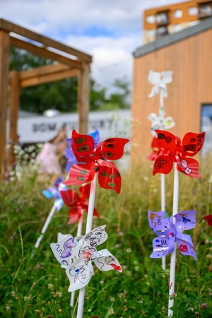 Owacje w Dom.Ku! - Wiatraczki wykonane na warsztatach w DKW w przestrzeni zielonej przed domem kultury