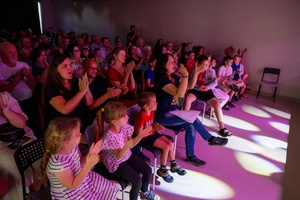Owacje w Dom.Ku! - Publiczność oklaskująca młodych aktorów występujących w spektaklu teatralno-muzycznym "Rzecz o dorastaniu"