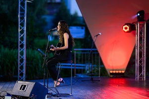 Koncert: "Ballady na głos i gitarę" - Łucja Kania - Na scenie śpiewająca i grająca na gitarze Łucja Kania