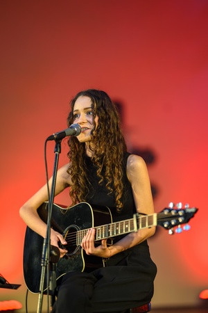 Koncert: "Ballady na głos i gitarę" - Łucja Kania - Na scenie śpiewająca i grająca na gitarze Łucja Kania