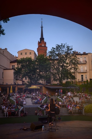 Koncert: "Ballady na głos i gitarę" - Łucja Kania - Amfiteatralna publiczność wsłuchująca się w piosenki w wykonaniu Łucji Kani