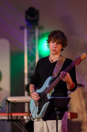 Koncert: Bored Students Orchestra - Na scenie grający na gitarze Mikołaj Skórka