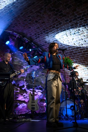 Koncert: Ania Szlagowska - Wokalistka Ania Szlagowska występuje z zespołem muzycznym podczas koncertu.