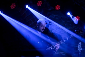 Koncert: Ania Szlagowska - Muzyk grający na instrumencie podczas koncertu na oświetlonej scenie.