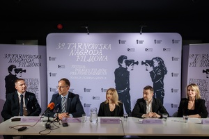 39 TNF: Konferencja prasowa - Od lewej: dyrektor TCK Tomasz Kapturkiewicz, prezydent Tarnowa Jakub Kwaśny, dyrektorka 39. TNF Magdalena Piątek, dyrektor artystyczny 39. TNF Kuba Armata, zastępca dyrektora TCK Dominika Dąbek za stołem konferencyjnym na tle wizualizacji festiwalowej