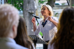 Koncert Chóralne Majówki: Chór Fox Vox - Na amfiteatralnej scenie na pierwszym planie dyrygentka chóru Fox Vox Anna Podkościelna-Cyz
