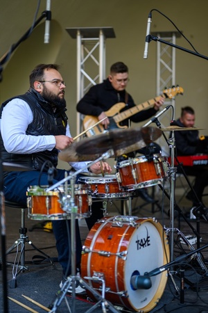 Koncert Chóralne Majówki: Chór SOLski - Na scenie na pierwszym planie grający muzycy Chóru SOLski (od lewej): perkusista Przemysław Kuta, basista Michał Kołodziej, pianista Piotr Niedojadło