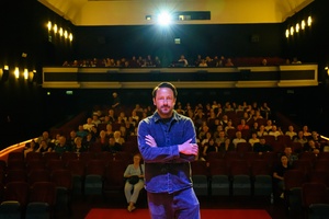 39. TNF: Dzień 3 (1.06.2025) - Na scenie Marzenia reżyser filmu "Światłoczuła" Tadeusz Śliwa w tle festiwalowa widownia w sali kinowej
