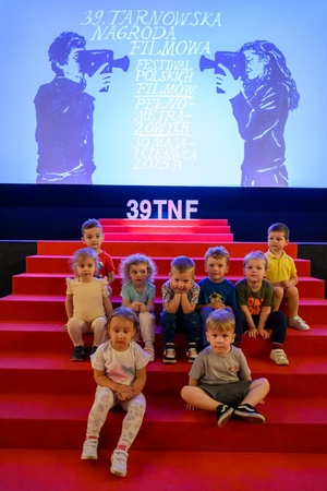 39. TNF: Dzień 4 (2.06.2025) - Najmłodsi widzowie na festiwalowych schodach w sali Marzenia przed projekcją