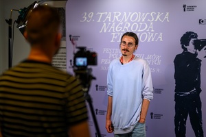 39. TNF: Dzień 8 (6.06.2025) - Maks Bereski na tle ścianki 39. TNF w hallu kina