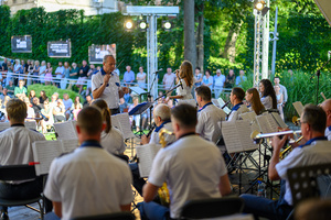 Koncert Polskiej Muzyki Rozrywkowej - Orkiestra Dęta Grupy Azoty S.A. i soliści - Na scenie grająca orkiestra dęta z perspektywy sceny, w tle publiczność