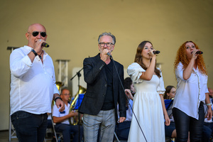 Koncert Polskiej Muzyki Rozrywkowej - Orkiestra Dęta Grupy Azoty S.A. i soliści - Na amfiteatralnej scenie na pierwszym planie (od lewej) śpiewający: Marek Ostrowski, Tomasz Stec, Aleksandra Wojnarska, Magdalena Stalmach