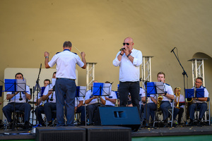 Koncert Polskiej Muzyki Rozrywkowej - Orkiestra Dęta Grupy Azoty S.A. i soliści - Na scenie śpiewający solista Marek Ostrowski, w tle grająca orkiestra