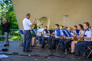 Koncert Polskiej Muzyki Rozrywkowej - Orkiestra Dęta Grupy Azoty S.A. i soliści - Na scenie śpiewający solista Tomasz Stec i grająca Orkiestra Dęta Grupy Azoty S.A. pod dyrekcją Jacka Skrzelowskiego