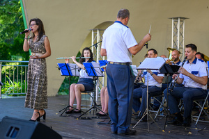 Koncert Polskiej Muzyki Rozrywkowej - Orkiestra Dęta Grupy Azoty S.A. i soliści - Na scenie śpiewająca solistka Marcelina Cieślik i grająca orkiestra dęta pod dyr. Jacka Skrzelowskiego