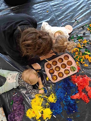 Warsztaty sensoplastyczne - Uczestnicy warsztatów wraz z opiekunem podczas zabawy galaretką i makaronem