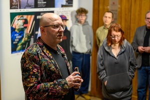 Wystawa: w cyklu Wernisaże Dzień po Dniu - Tomasz Sobczak podczas przemowy, w tle kilku autorów.