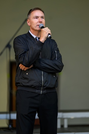 Koncert Chóralne Majówki: Chór Fox Vox - Na amfiteatralnej scenie dyrektor TCK Tomasz Kapturkiewicz zapowiadający przed publicznością występ Chóru Fox Vox