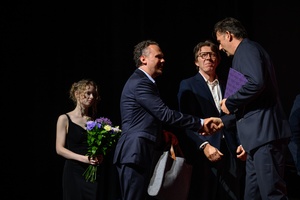 40. TNF: Gala Wręczenia Nagród - Na scenie Marzenia Prezes MGGP S.A. Paweł Grad gratulujący Maciejowi Sobieszczańskiemu. W tle wolontariuszka 40. TNF i Daniel Bloom