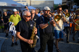 Starówka Jazz Festival – Enerjazzer / Slavia Dixieland Band - Muzycy jazzowi grający na instrumentach podczas radosnego marszu z Rynku do Amfiteatru w Tarnowie w otoczeniu mieszkańców.