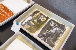 Warsztaty fotograficzne: Guma dwuchromianowa - Prace w procesie płukania zanurzona w wodzie w kuwecie.