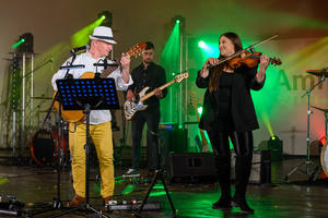 Koncert: Paragrafy i nuty - Wiesław Hudyma występujący na scenie amfiteatru w towarzystwie muzyków