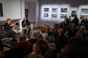 Wystawa: Zrozumie życie - Marek Grygiel i Tadeusz Koniarz w drugim planie i fragment publiczności spotkania.